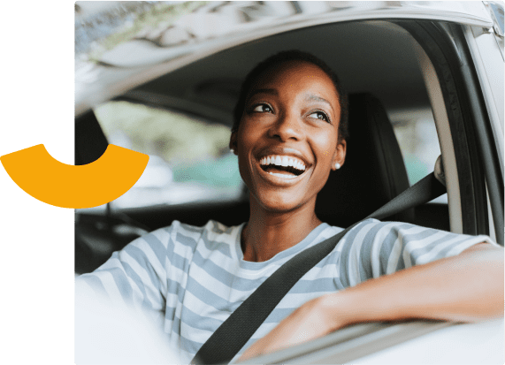 Mulher negra sorrindo dirigindo um carro